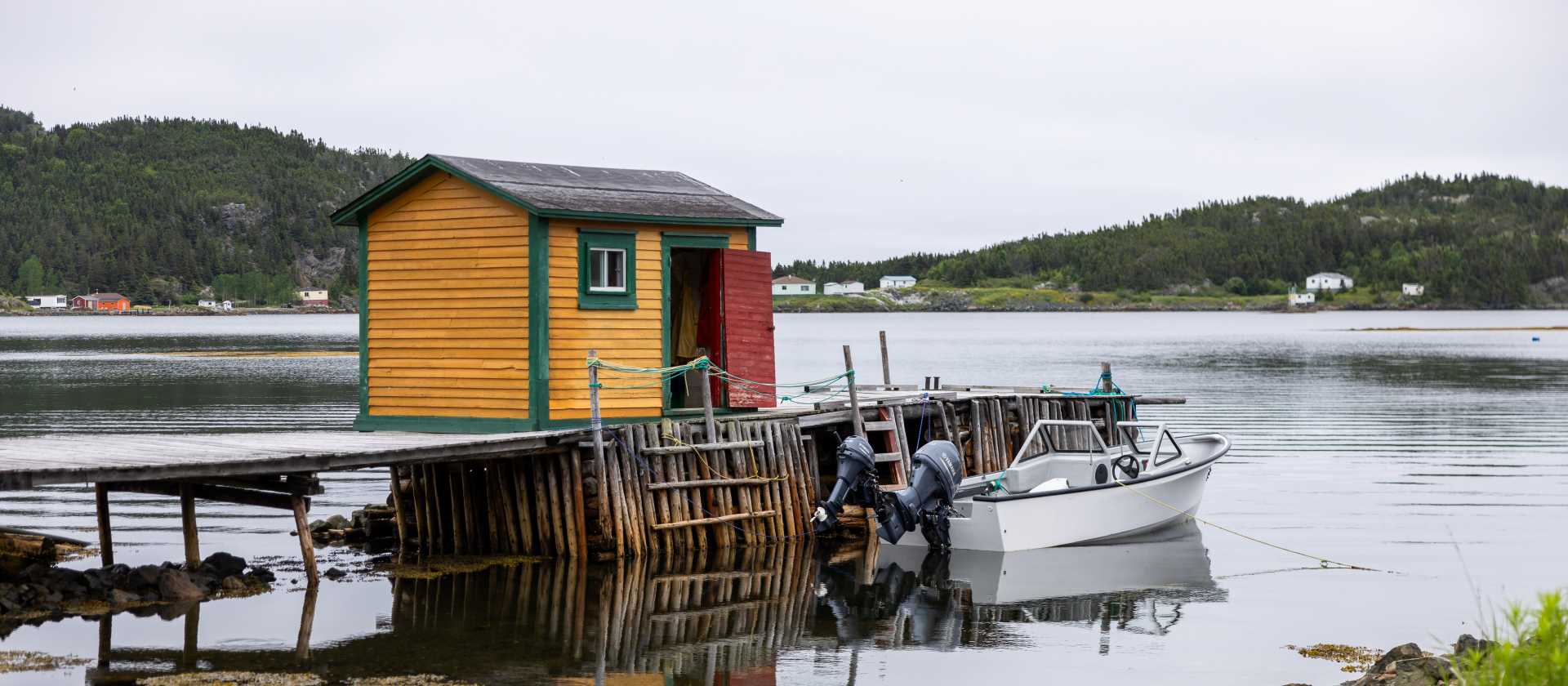 A traditional fishing stage and small boat reflect the life of a Newfoundland outport community | Tom Cochrane
