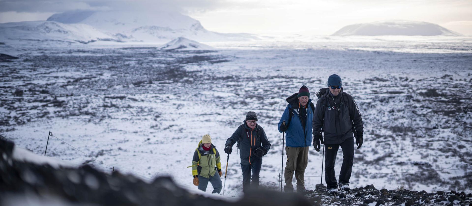 Iceland hike across a snow dusted volcanic landscape beneath distant peaks | Jacques Marais