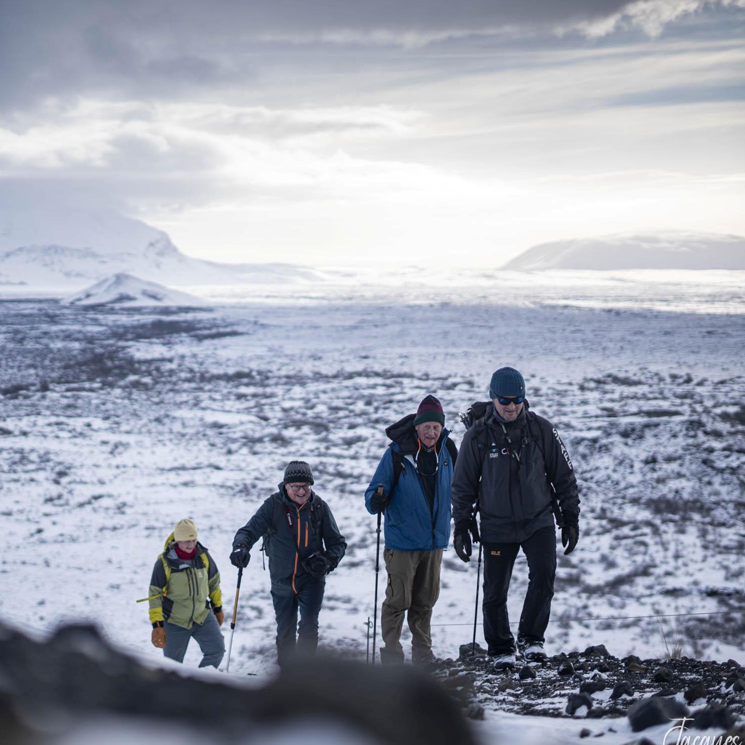 Iceland hike across a snow dusted volcanic landscape beneath distant peaks | Jacques Marais