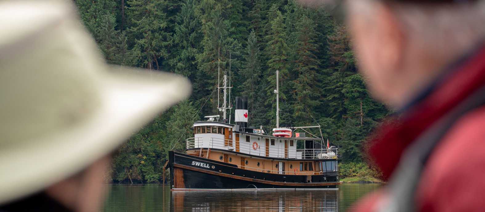 Guests view the expedition ship at anchor in a sheltered coastal inlet