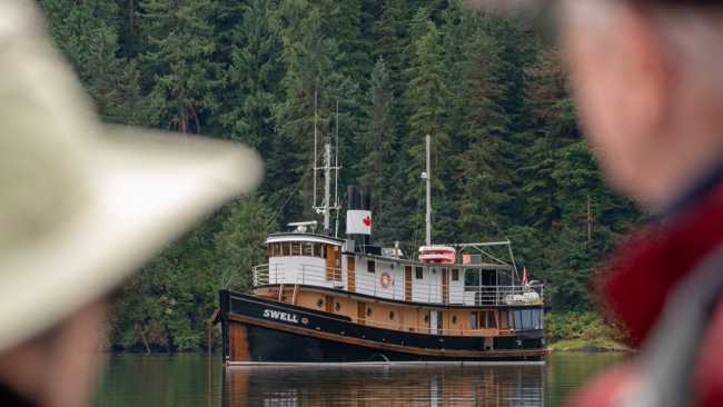 Guests view the expedition ship at anchor in a sheltered coastal inlet