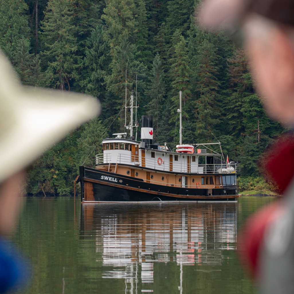 Guests view the expedition ship at anchor in a sheltered coastal inlet