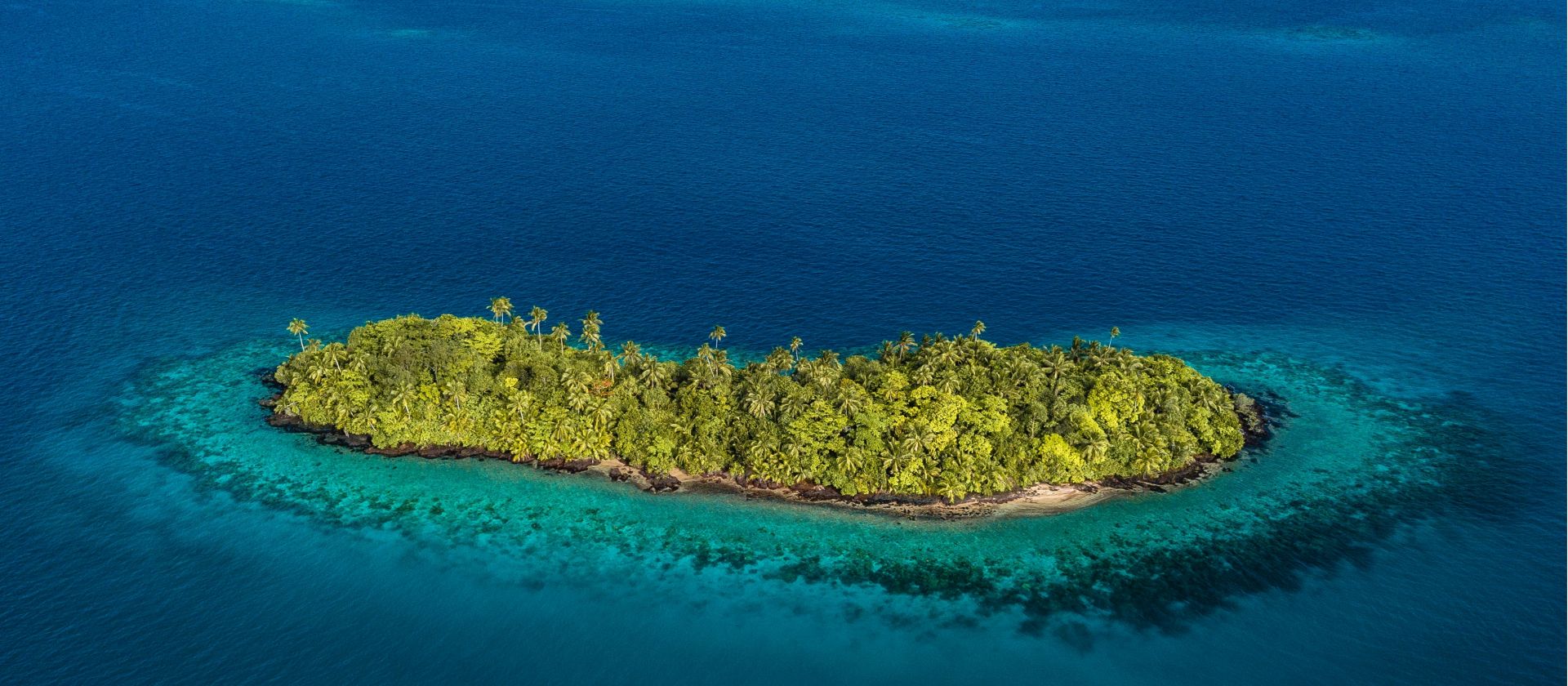 Wallis and Futuna islet fringed by coral reef in a turquoise lagoon