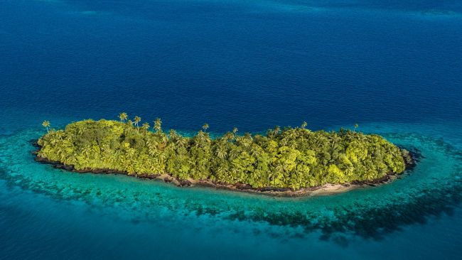 Wallis and Futuna islet fringed by coral reef in a turquoise lagoon